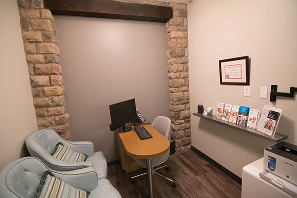 The consultation room with a desk and two chairs.