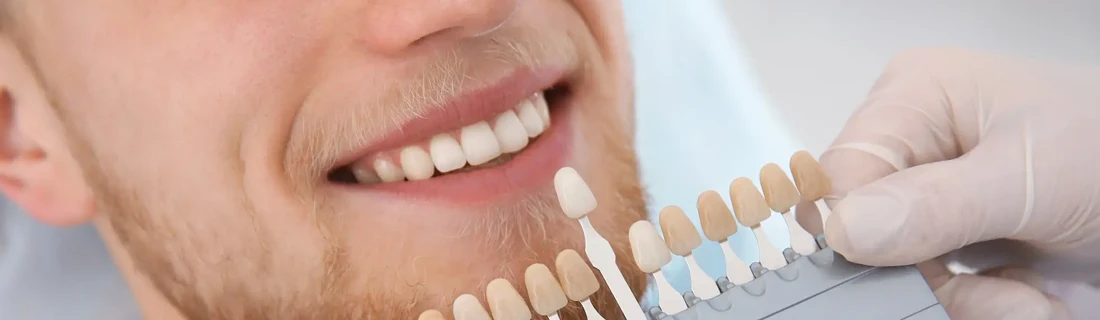 Dentist Avondale AZ Cosmetic Dentistry A dentist holding up cosmetic teeth to compare with a patients current teeth.