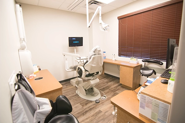 An exam room with a dental chair in the center of it.