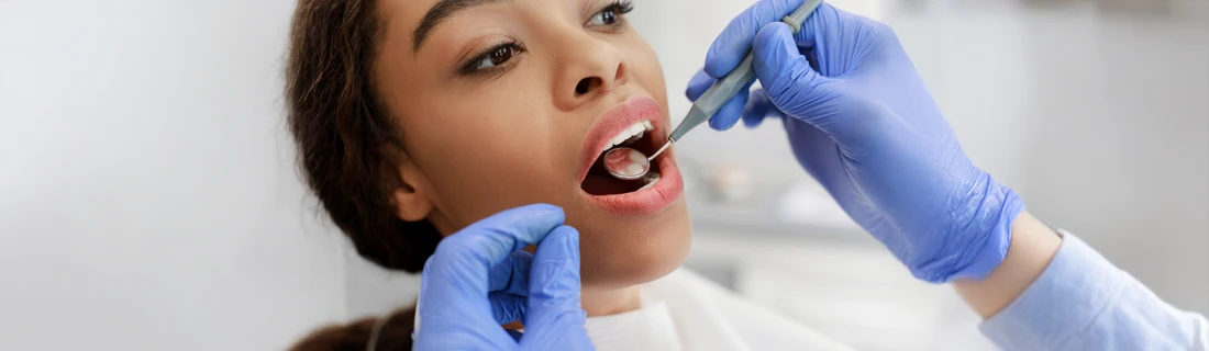Dentist Avondale AZ First Exam A person receiving a mouth exam from a person wearing blue gloves.