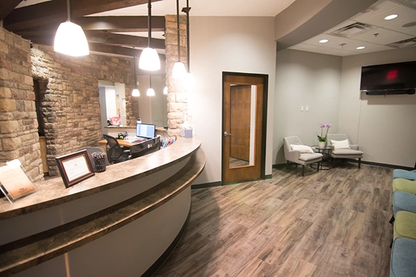 A view of the front desk. The back wall is brick and the ceiling as wooden beams.