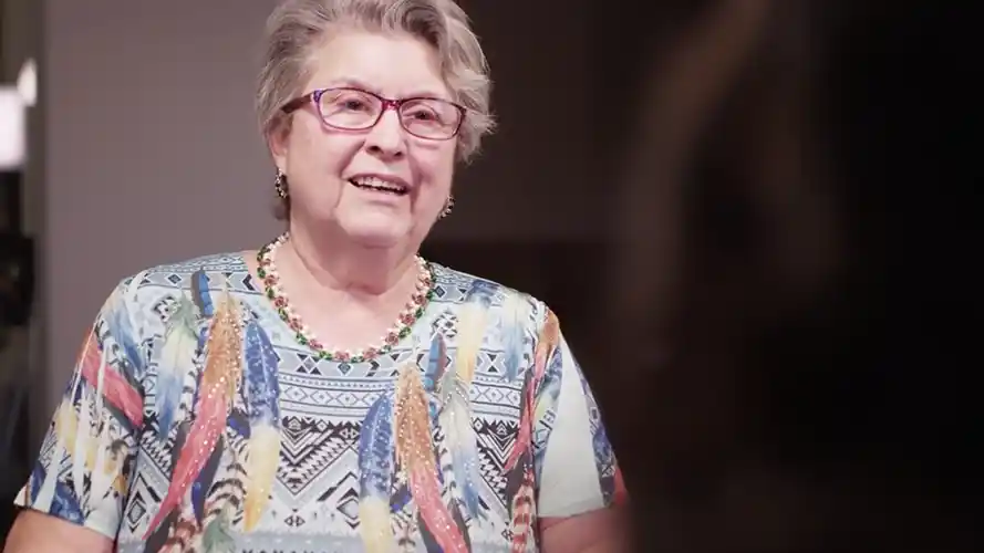 Joanne smiling while wearing red glasses.